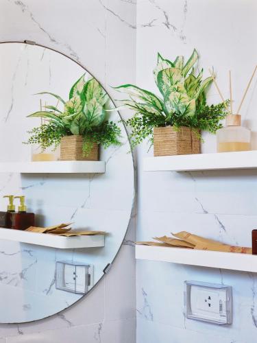 a mirror on a wall with plants at Seafront Apartment TMS Quy Nhơn in Quy Nhon