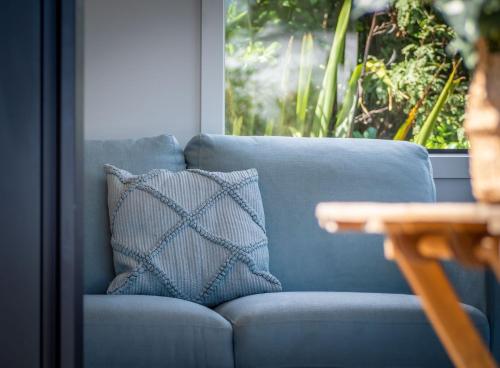 a blue couch with a pillow on a table at Pukeko Studio in Pohara