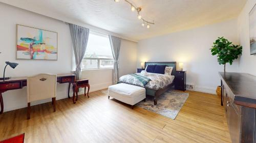 a bedroom with a bed and a table and a desk at Comfortable & Spacious Private Room with Ensuite in Corso Italia in Toronto
