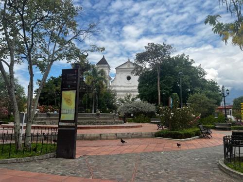 a building with a sign in the middle of a park at Hermoso apartasol en santafe de Antioquia. in Santa Fe de Antioquia