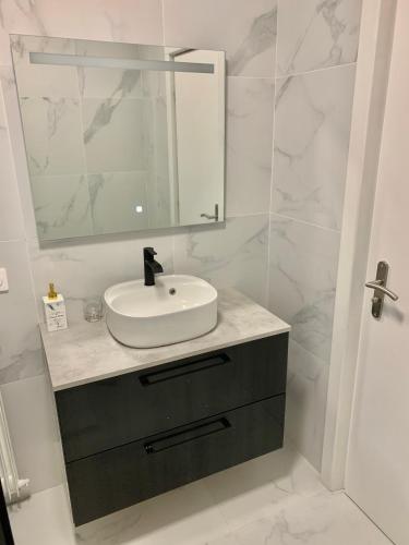 une salle de bain blanche avec un lavabo et un miroir dans l'établissement domaine du cheval d argent, à Saiguède