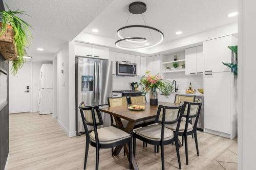 a kitchen and dining room with a table and chairs at Newly Built 2BR Mountain Escape in DT Canmore! in Canmore