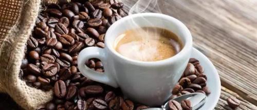 a cup of coffee sitting on top of coffee beans at Suíte independente apart hotel plaza Elysees 202B in Rio de Janeiro