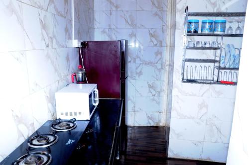 ムンバイにあるAngels Villaの小さなキッチン(コンロ、冷蔵庫付)