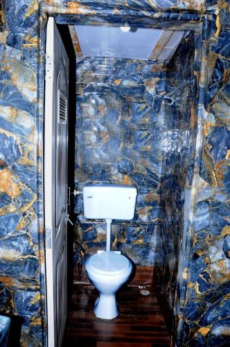 a bathroom with a toilet in a stone wall at Angels Villa in Mumbai