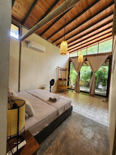 a bedroom with a bed in a room with windows at Casas La Floristería in Palomino