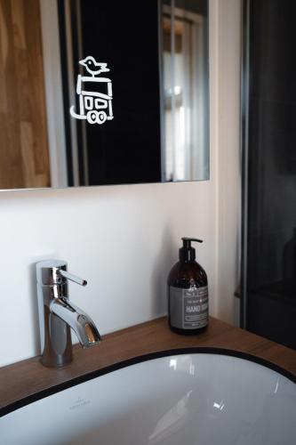 a bathroom sink with a bottle of soap on it at Tiny SeaSide - Loddenhøj in Lillekobbel