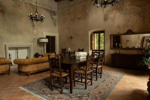 a dining room with a table and chairs and a couch at Palazzo Pirro Dimora Storica in Acciano