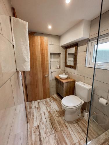 a bathroom with a toilet and a sink at Los Conejos Bariloche in San Carlos de Bariloche