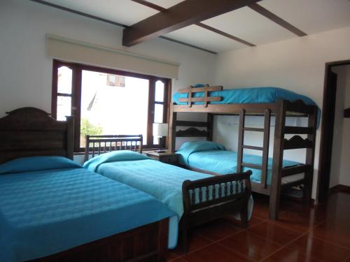 1 Schlafzimmer mit 2 Etagenbetten und einem Fenster in der Unterkunft Hospederia Villa Berenita in Villa de Leyva