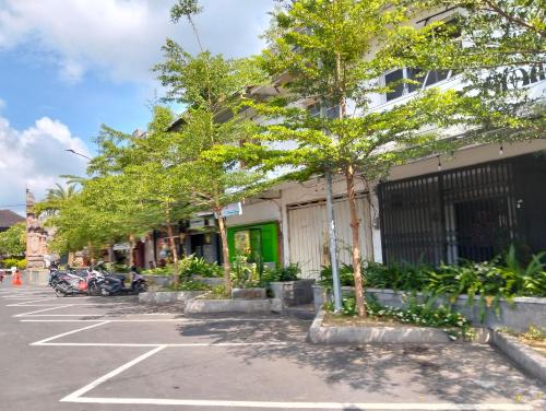 a parking lot with trees in front of a building at Bali Bakas House II in Banjarangkan