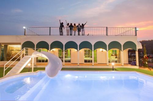 people standing on top of a building with a swimming pool at Paris De Floor Khaoyai in Pak Chong
