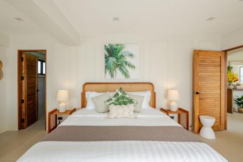 a bedroom with a large white bed with two lamps at Wayan House with Hotspring Pool in Los Baños