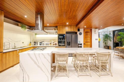 a kitchen with a large white island with bar stools at Wayan House with Hotspring Pool in Los Baños