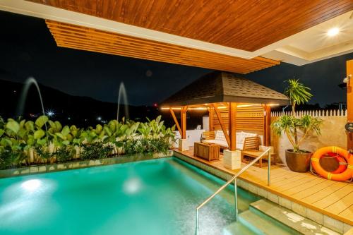 a swimming pool with a gazebo and a house at Wayan House with Hotspring Pool in Los Baños