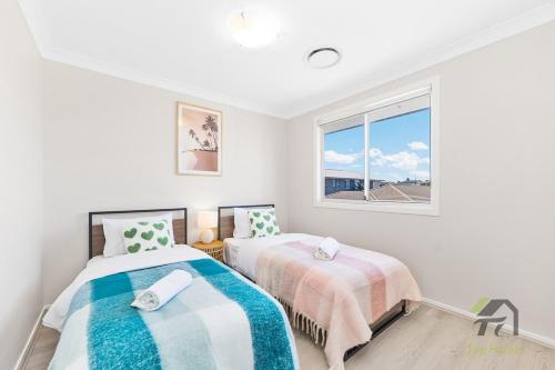 a bedroom with two beds and a window at The dream world of bindo in Schofields