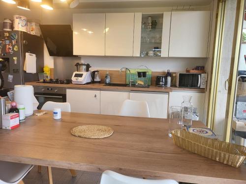 une cuisine avec une table en bois et des armoires blanches dans l'établissement free parking! great central apartment with sea view, à Nice