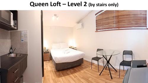a bedroom with a bed and a table with chairs at Dunsborough Bay Village Resort Suites in Dunsborough