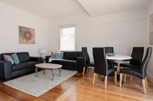 a living room with a couch and a table and chairs at Renovated Homely Home in Newstead