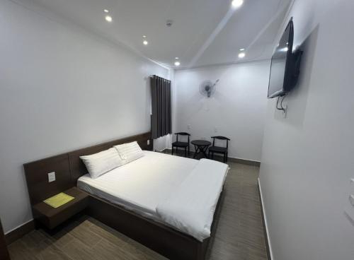 a small room with a bed and a tv at Khách Sạn Hoa Phượng in Ho Chi Minh City