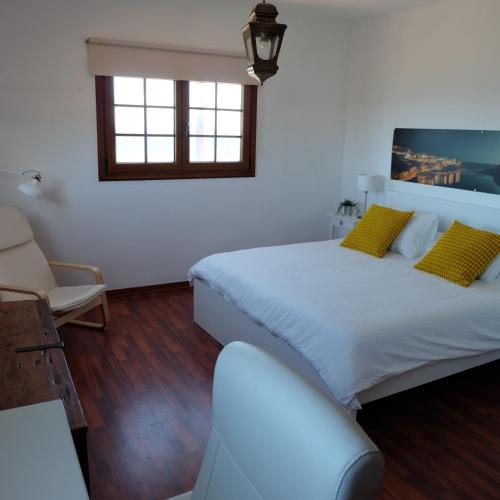 a bedroom with two beds and a couch and a window at Casa QUILI in La Caleta