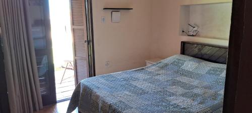 a bedroom with a bed with a blue comforter at Apartamento na Barra do Chuí Brasileira in Santa Vitória do Palmar