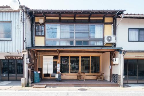 a building with tables and chairs in front of it at フロント無人管理 コワーキング付き古民家ゲストハウス チェックイン対応不要 in Satogata