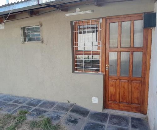 a wooden door and a window on a house at Casita Las Lavandas in El Bolsón