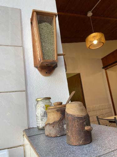 a counter top with two logs and jars on it at Casita Las Lavandas in El Bolsón