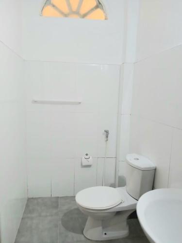 a white bathroom with a toilet and a sink at Green Peak - Mountain View Hotel & Restaurant in Ella
