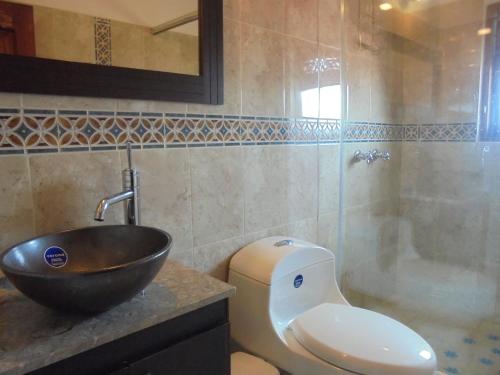 y baño con lavabo, aseo y bañera. en Hospederia Villa Berenita, en Villa de Leyva