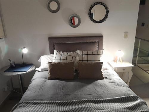a bedroom with a bed with pillows and a mirror at Duplex en salta in Destilería Chachapoyas