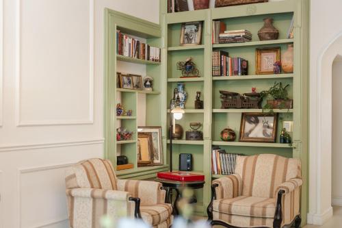 a living room with two chairs and a book shelf at Villa Ganz Boutique Hotel in Guadalajara