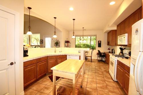 a kitchen with wooden cabinets and a table in it at Rancho Manana Private Home - C8912 in Cave Creek