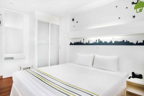 a bedroom with a white bed with a city picture on the wall at The Phoenix Hotel Bangkok - Suvarnabhumi Airport in Lat Krabang