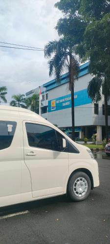 a white van parked in front of a building at Lajeka Rental Mobil Makassar in Makassar