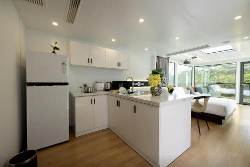 a kitchen with white cabinets and a white refrigerator at Damyang Lisa Forest Village in Damyang