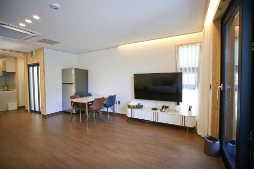 a room with a table and a large screen television at Damyang Lisa Forest Village in Damyang