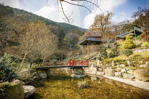 a bridge over a pond in front of a house at Damyang Lisa Forest Village in Damyang