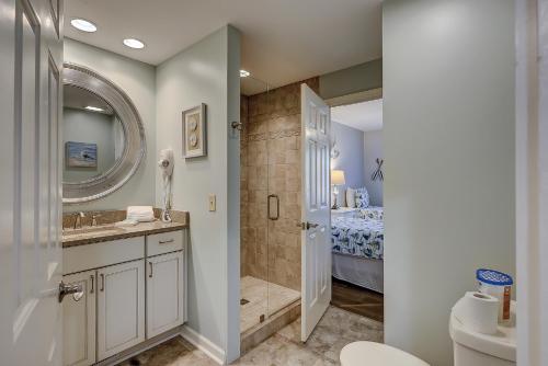 a bathroom with a shower and a toilet and a bed at Wonderful luxury condo with great golf views K Bed Beach gear & bike rentals in Hilton Head Island