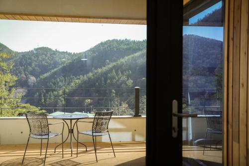 a table and chairs on a balcony with a view of a mountain at Damyang Lisa Forest Village in Damyang