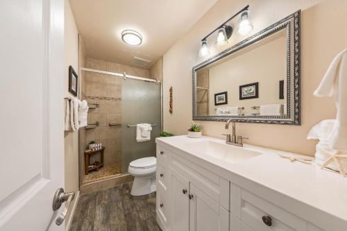 a bathroom with a sink and a toilet and a mirror at Maui Sands Seaside 713 · MSS 713 Charming 1BD Near Beach in Kahana