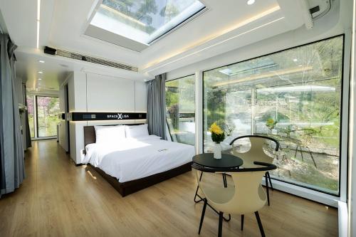 a bedroom with a bed and a table and a window at Damyang Lisa Forest Village in Damyang