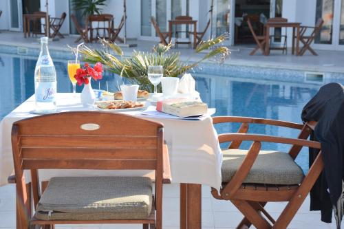 a table with a plate of food next to a pool at Les Jardins de Toumana in Triffa