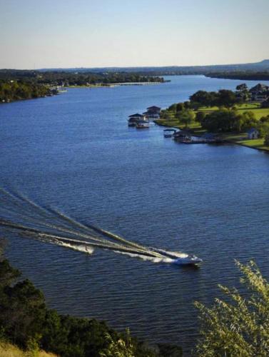 a group of boats traveling down a river at Mins to Granbury Med Ctr, Mins to Lake, Firepit, Stunning Modern Kitchen in Granbury