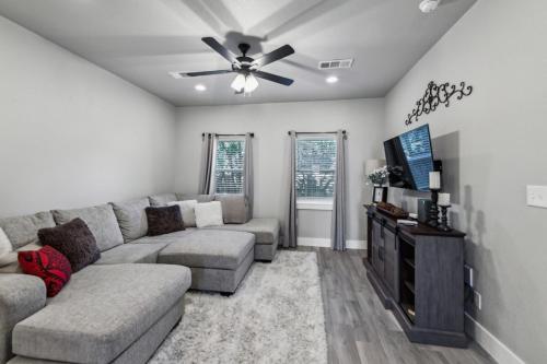 a living room with a couch and a ceiling fan at Mins to Granbury Med Ctr, Mins to Lake, Firepit, Stunning Modern Kitchen in Granbury