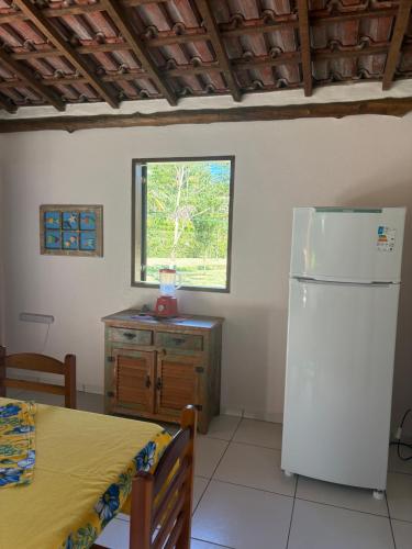 une cuisine avec un réfrigérateur, une table et une fenêtre dans l'établissement Casa da Jane, à Parati