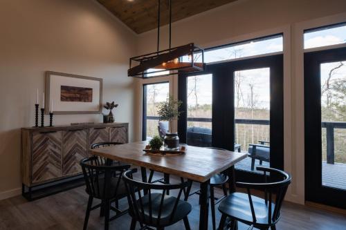 a dining room with a wooden table and chairs at A Red River Barnhouse in Rogers
