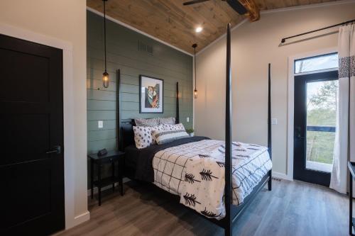 a bedroom with a bed and a window at A Red River Barnhouse in Rogers