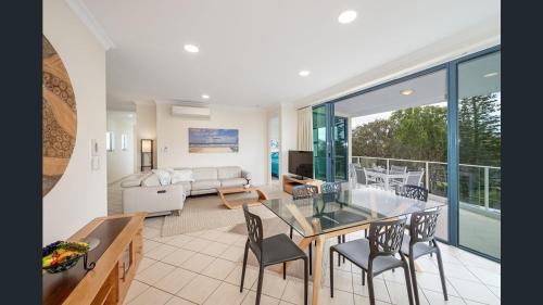 a living room with a table and chairs at Sea Breeze At Mudjimba Beachside, Tennis Pool in Mudjimba